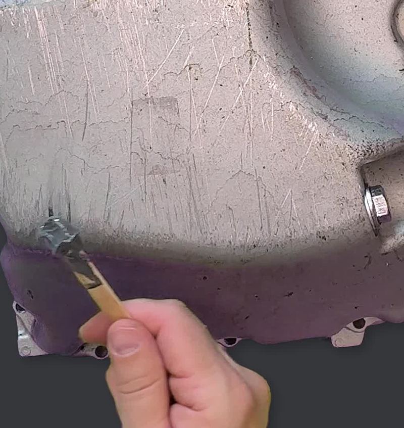 Applying J-B Weld epoxy to repair a cracked engine part